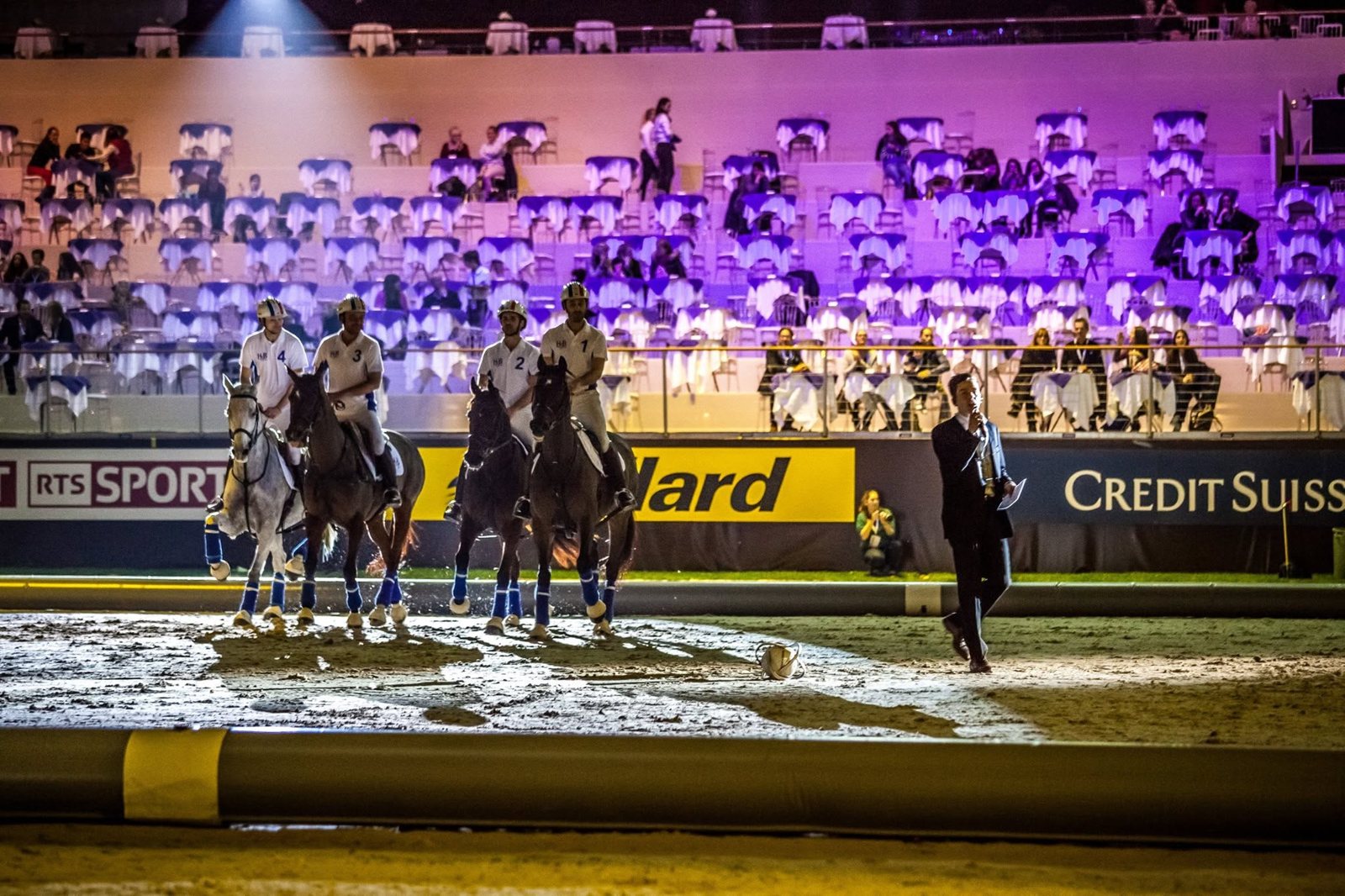 Maxime au micro sur la piste du Palexpo de Genève, devant quatre cavaliers